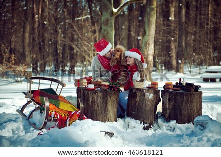 loving couple in the winter woods with a dog