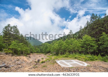 Helicopter pad on peak of mountain with cloud sky