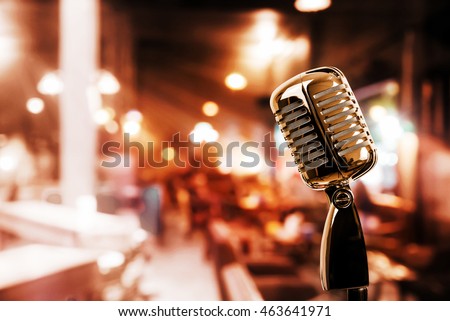Retro microphone against blur colorful light in pub and restaurant background Royalty-Free Stock Photo #463641971