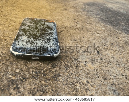 Broken smartphone on concrete floor.Cellphone on the cement floor with broken display.