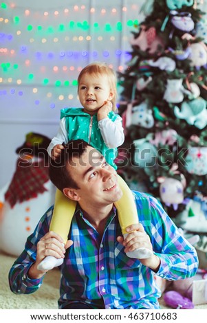 young father holding his daughter on his shoulders
