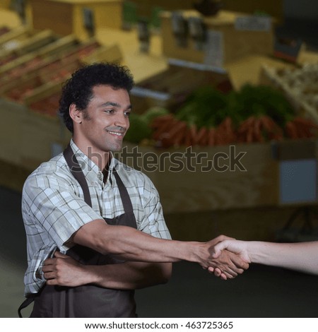 Young Grocery clerk working in produce aisle of grocery store