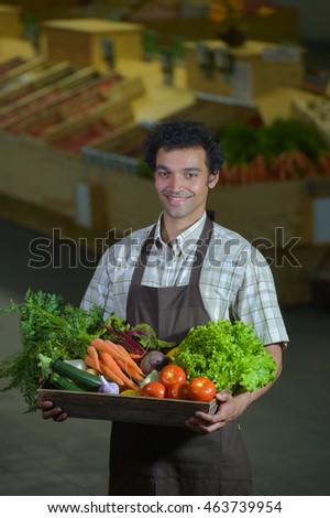 Young Grocery clerk working in produce aisle of grocery store