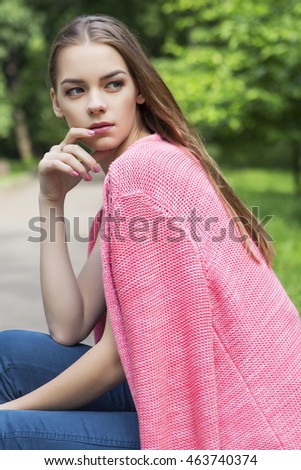 Beautiful brunette woman in neutral casual outfit walking in park. Lifestyle portrait. Summer day