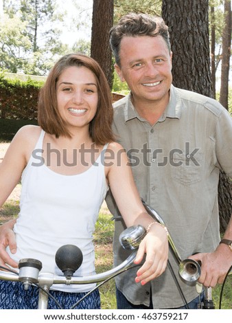 Happy smiling couple riding in the park