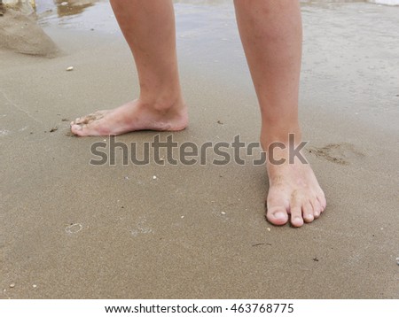 Child feet on sand beach