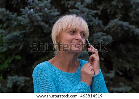 Smiling ellderly woman has a conversation by phone