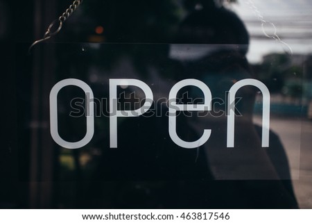 open sign broad through the glass of window at coffee shop