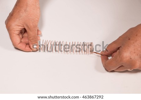 Hand try to pull Spiral spring on white background