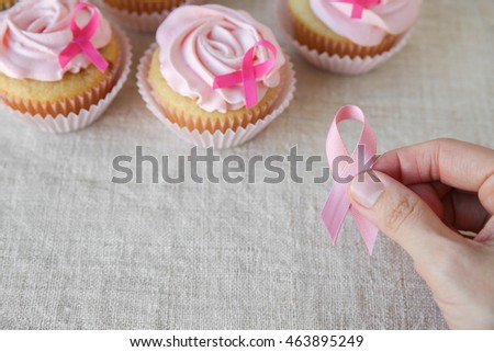 holding pink ribbon with Rose flower cupcakes for pink ribbon day, Breast cancer awareness