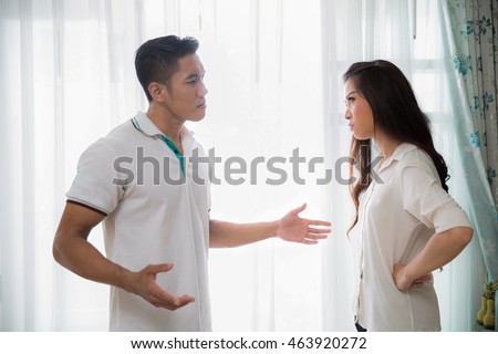 Image of young man quarreling with his wife at home while screaming and scolding his wife, family concept, 