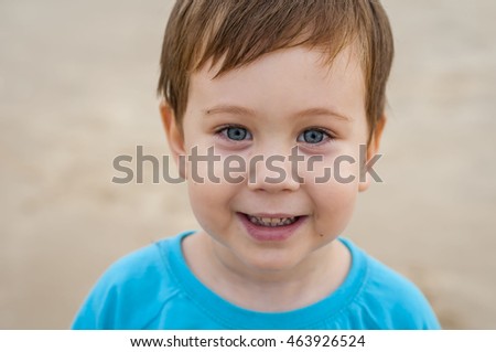 Happy little 3 year old Caucasian boy with blue eyes smiling.