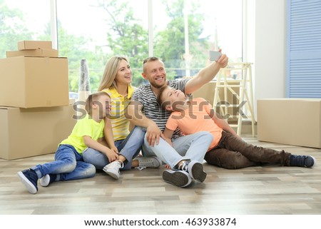 Happy family taking photo with phone in room