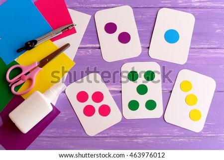 Colored flash cards for toddler, preschooler. How to teach colors to kid. How to teach child to count. Flashcards, scissors, cardboard on wooden background. Early development in kindergarten, at home 