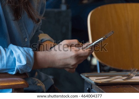 Mobile phone and women on wood table in coffee shop or restaurant