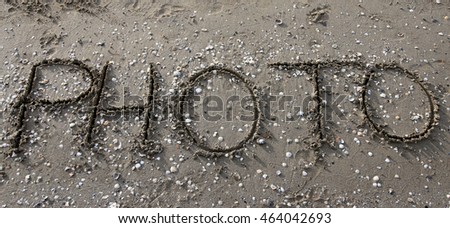 big PHOTO written on the beach sand