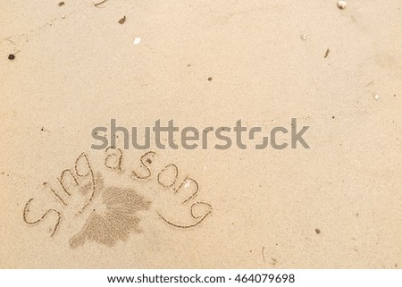 written words "sing a song" on sand of beach
