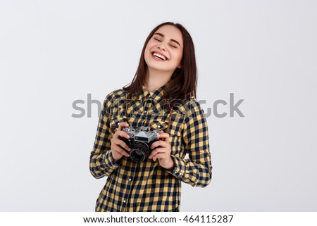 Young beautiful smiling brunette photographer over white background.