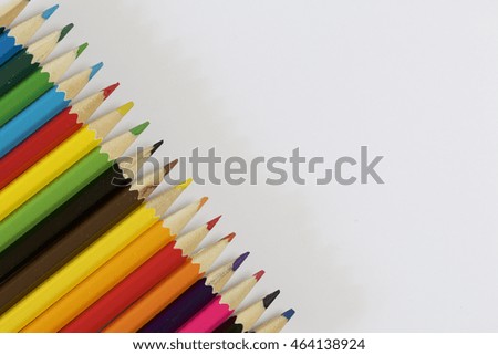 Colored pencils. Located next to the frame on the diagonal. On a white background.