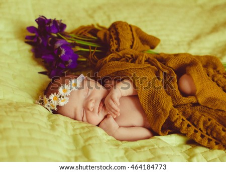 little  child in a wreath of flowers sleeps soundly on the bed