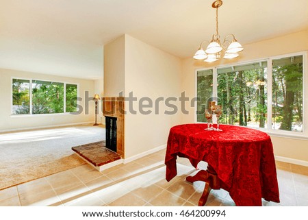 Tile floor dining room interior with elegant red table cloth. The room is connected with empty living room. Northwest, USA