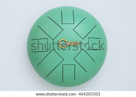 Mint	steel tongue drum with two sticks and jew's harp on white
