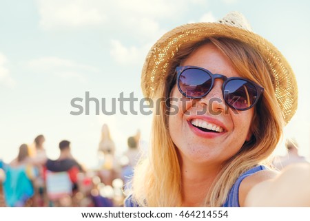 Young beautiful woman taking a selfie at the beach bar
