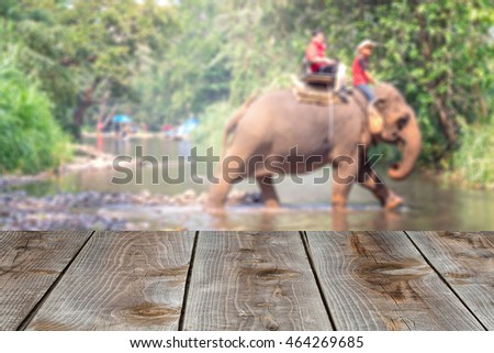 Perspective wood with blurred people ride elephant activities in park background, product display montage, spring and summer season.