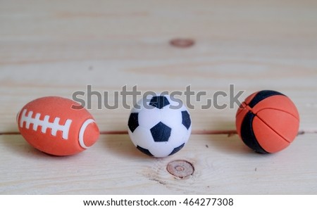 Toys rubber rugby football basketball on wood background.