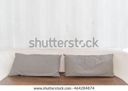 Wooden chair with  pillow and white wall 