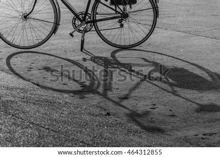 Black and white silhouette bicycle with solid shadow on the street