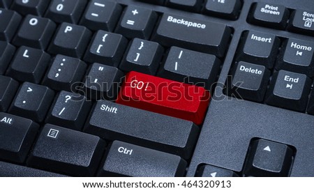 Close up on customized computer enter button on keyboard with a word go.
