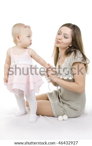 Young and beautiful mother with her sweet little daughter isolated on white.