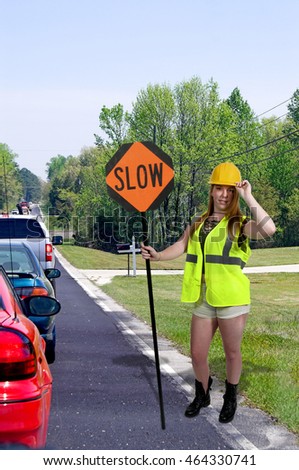 Woman flagman holding a sign to slow traffic
