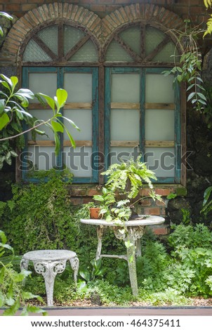 white chair and beautiful vintage window frames in the cottage garden
