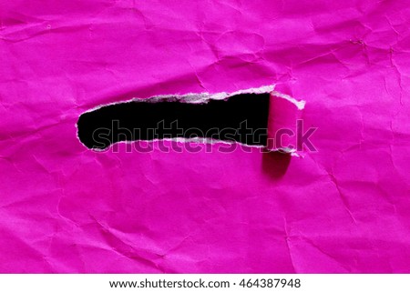 hole torn paper over black background
