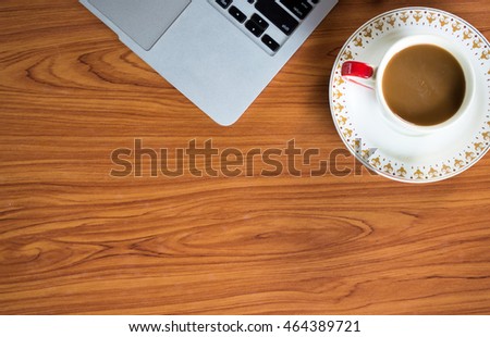 Office table with notepad, laptop and coffee cup.View from above with copy space.
