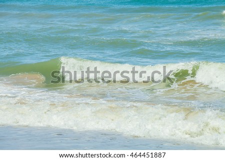 Sea, sand and big wave front with bubbles and splashes at Thailand.