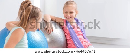 Two girls laughing and talking during a break in the exercises