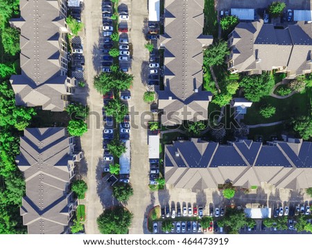 Aerial view of apartment garage with full of covered parking, cars and green trees of multi-floor residential buildings in Houston, TX in early morning. Urban infrastructure and transportation concept