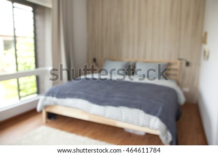 Blurred bedroom with white and grey bed