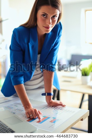 Portrait of a beautiful business woman standing near her workplace.