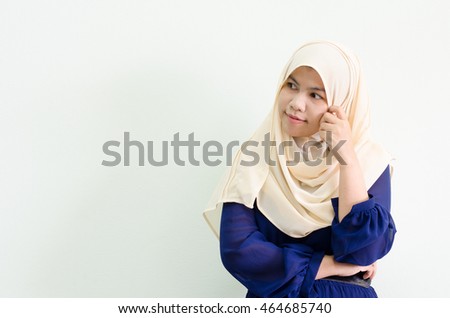 Attractive portrait of asian young muslim woman while thinking on white background with blank area for sign or copyspace.  Concept for idea, business, creative, thoughtful