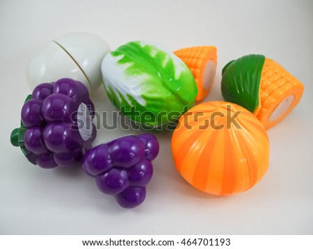 A plastic toy grape, egg, vegetable, corn and garlic on white background.