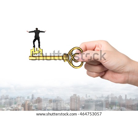 Rear view of man balance on treasure key in pound sign shape with hand holding, on urban scene background.
