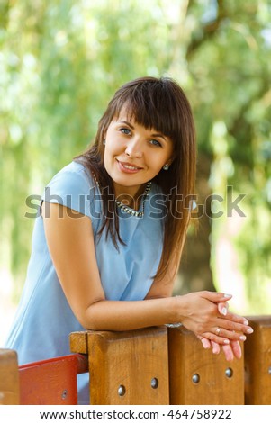 Beautiful young woman standing on the bridge in the park