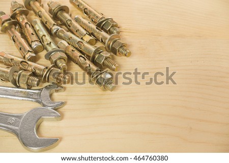 wrench Bolts and screws used in construction on the wood background.