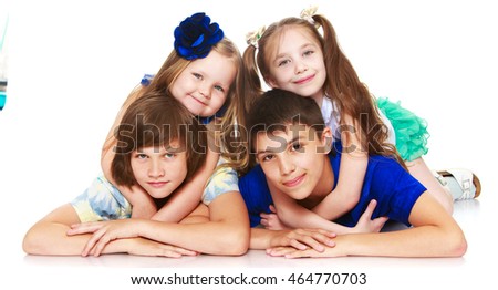 Horizontally elongated rectangular frame. Two little girls sisters lie on top of his brothers and hugging them around the neck. The picture shows 4 children - Isolated on white background