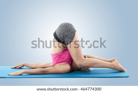 Young blond haired woman performing yoga on blue exercise mat.
