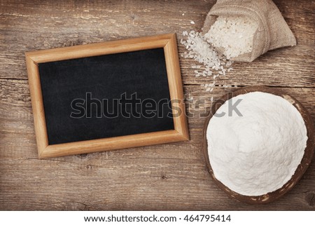 rice flour in a wooden bowl, rice on the old wooden background with copy space (Top view )